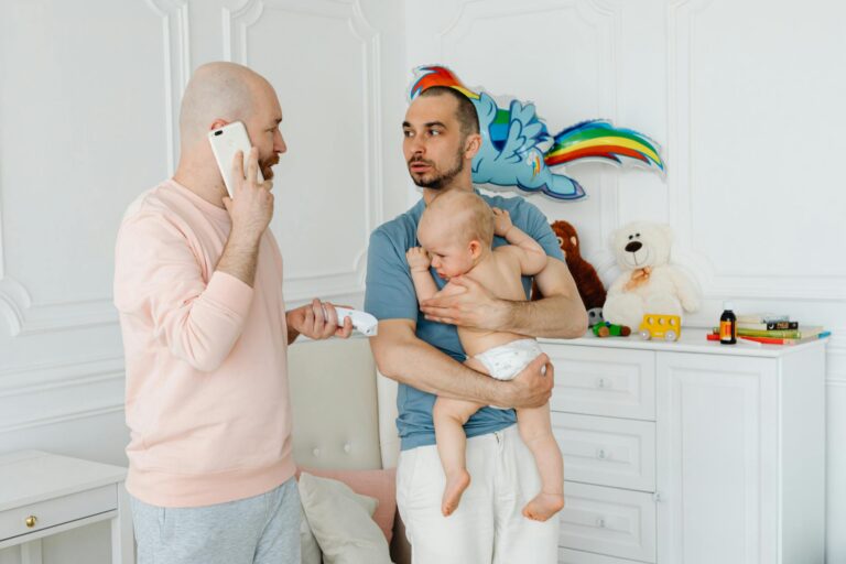 A heartwarming scene of two fathers lovingly caring for their baby indoors.